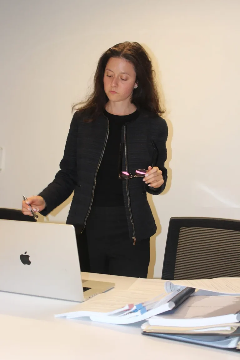 Toronto Litigation Lawyer Yeliz Beygo stands at her office desk looking down at a laptop
